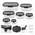 Set of clear airtight food storage containers with black lids in various sizes flat lay on white background